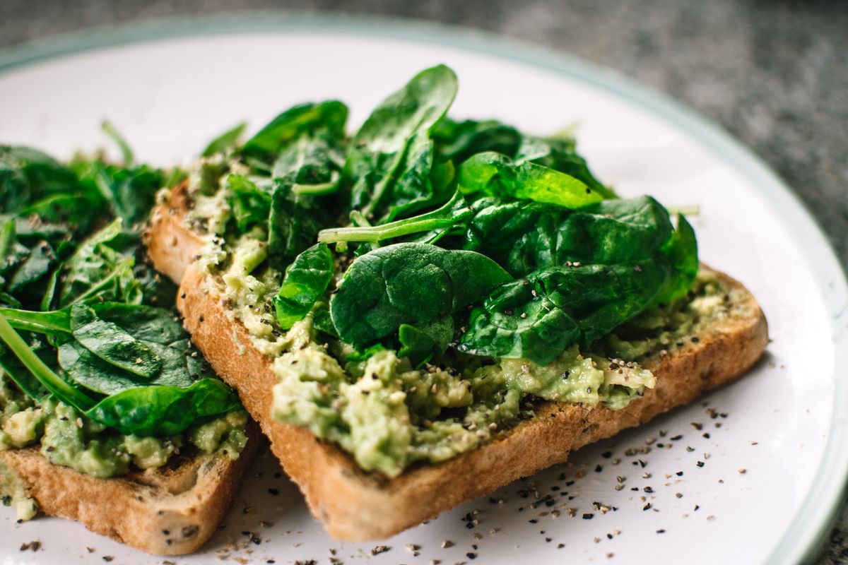 Illustrative food photograph: smashed pea toast with herbs