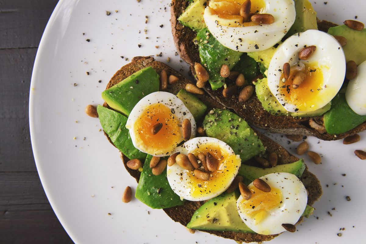 Illustrative food photograph: avocado and egg toast with a lemon finish